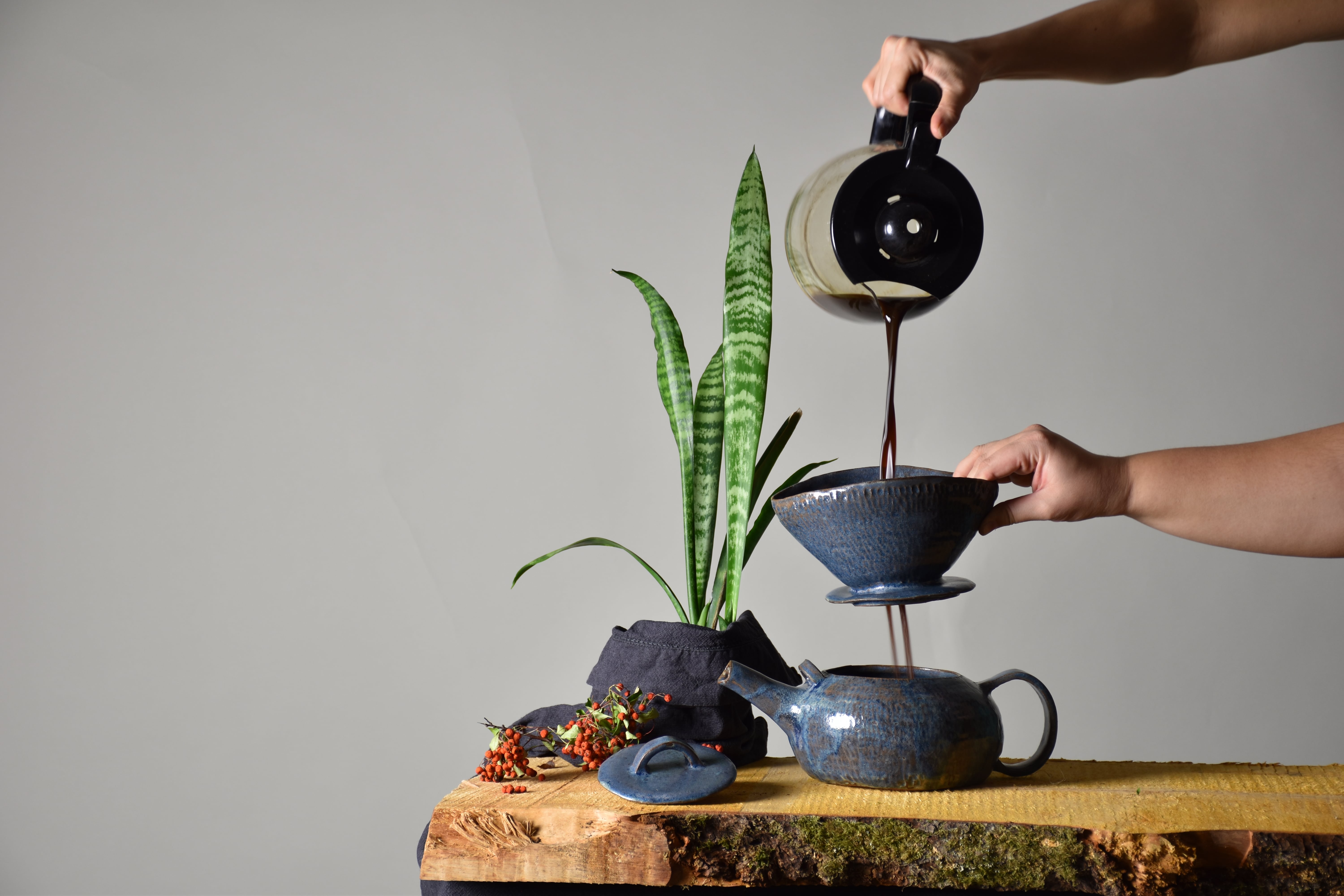 a ceramic coffee set with a coffee being poured into it